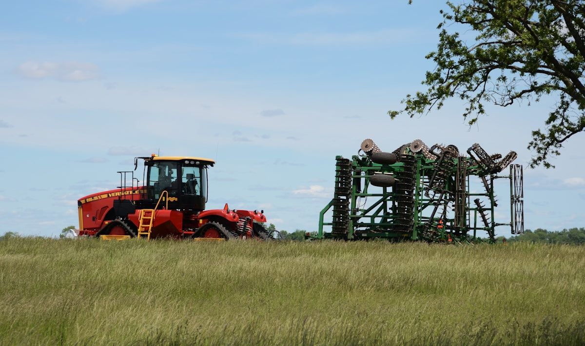 A tractor and farm equipment in a field.