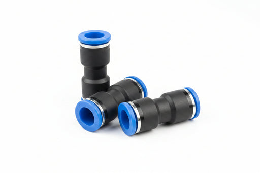 Black and blue plastic plumbing fittings on a metallic surface