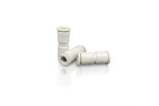 White plastic plumbing fitting on a reflective surface