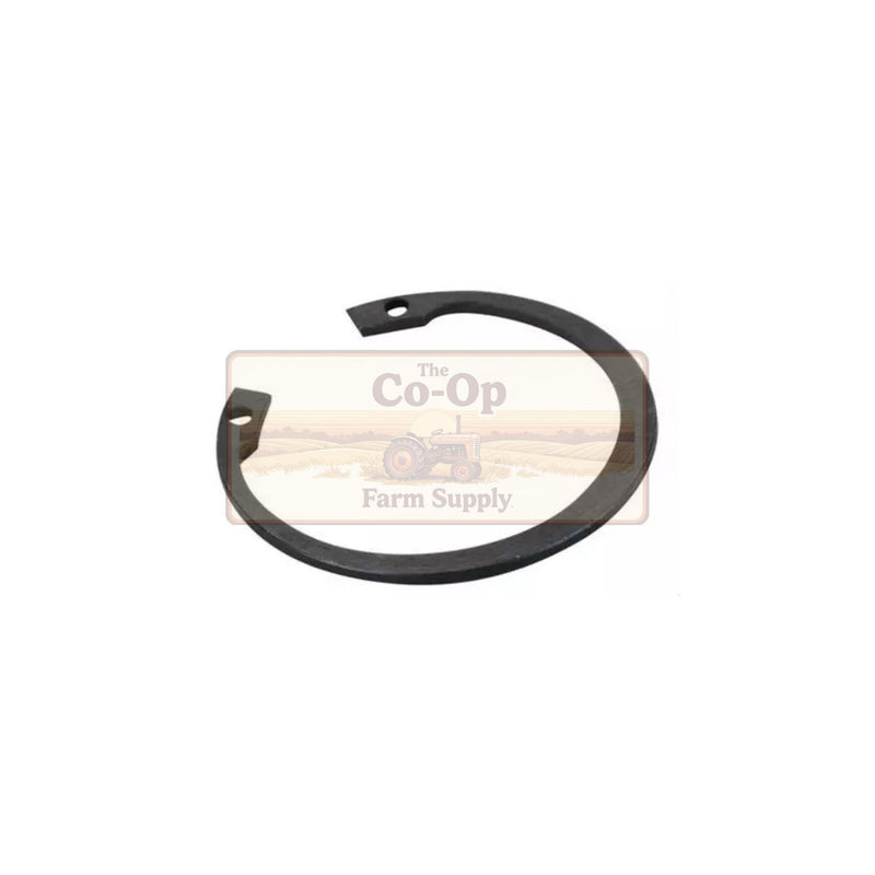 A black metal circular spring clip or gasket with two small mounting holes, shown on a white background with a faint 'The Co-Op Farm Supply' watermark behind it.