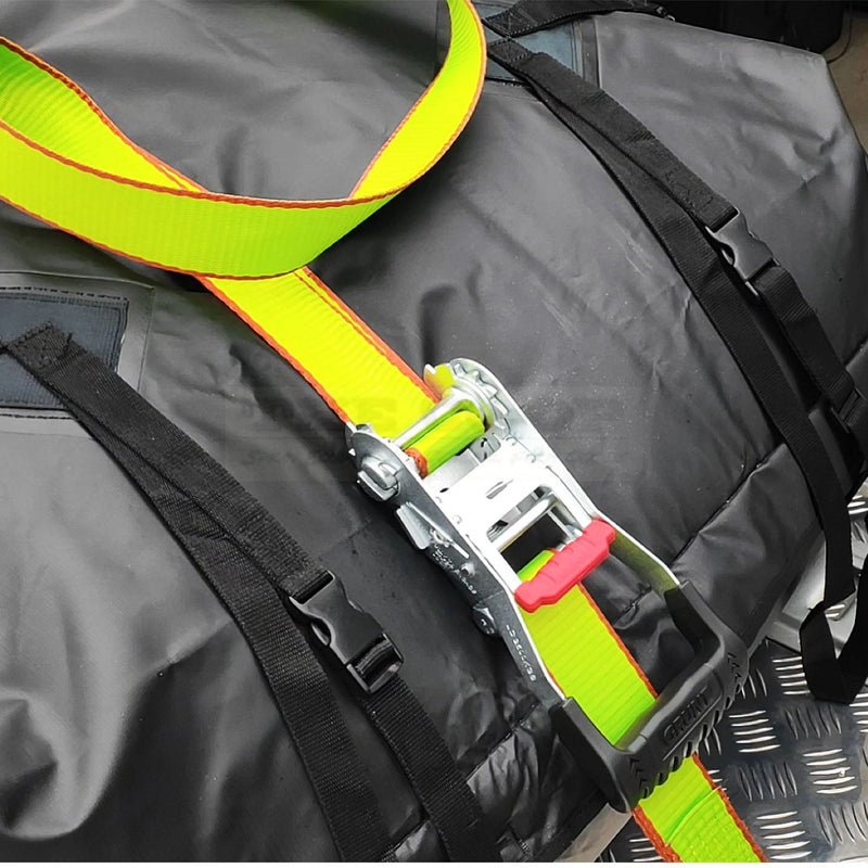 Close-up of a yellow strap with a red buckle on a black bag