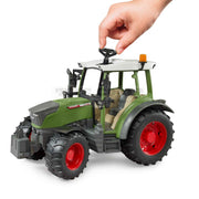 Toy model Fendt tractor with green body, red wheels, and grey accents on a white background